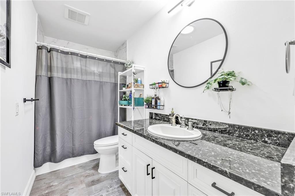 3231 13th Avenue Southwest Naples, FL 34117 - Photo 13 of 49 a bathroom with a granite countertop sink a toilet and a mirror