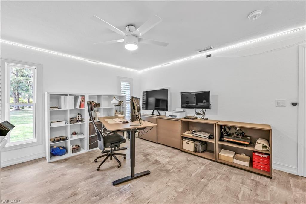 3231 13th Avenue Southwest Naples, FL 34117 - Photo 14 of 49 a view of a workspace with furniture and a flat screen tv