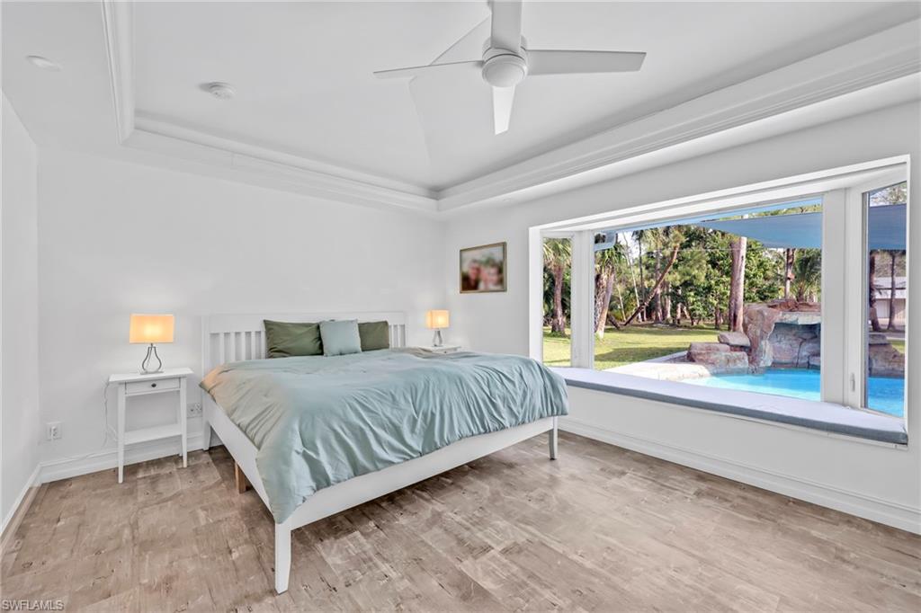 3231 13th Avenue Southwest Naples, FL 34117 - Photo 19 of 49 a bedroom with a large bed and a large window