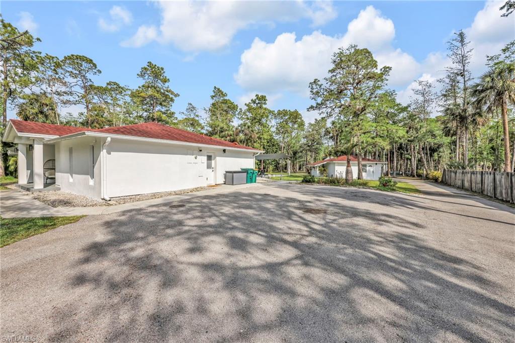 3231 13th Avenue Southwest Naples, FL 34117 - Photo 27 of 49 a view of a white house with a yard and parking space