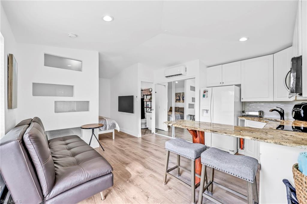 3231 13th Avenue Southwest Naples, FL 34117 - Photo 29 of 49 a living room with stainless steel appliances furniture a rug and a kitchen view