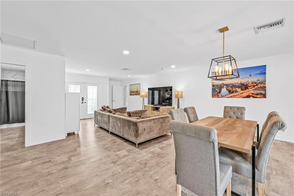 3231 13th Avenue Southwest Naples, FL 34117 - Photo 8 of 49 a living room with furniture a dining table and chairs with wooden floor