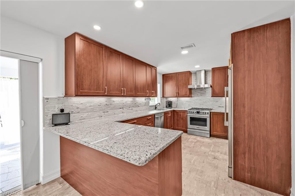 3231 13th Avenue Southwest Naples, FL 34117 - Photo 9 of 49 a kitchen with stainless steel appliances granite countertop a sink stove and refrigerator