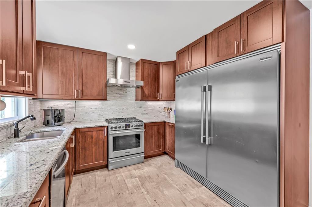 3231 13th Avenue Southwest Naples, FL 34117 - Photo 10 of 49 a kitchen with stainless steel appliances granite countertop a refrigerator a sink a stove and oven