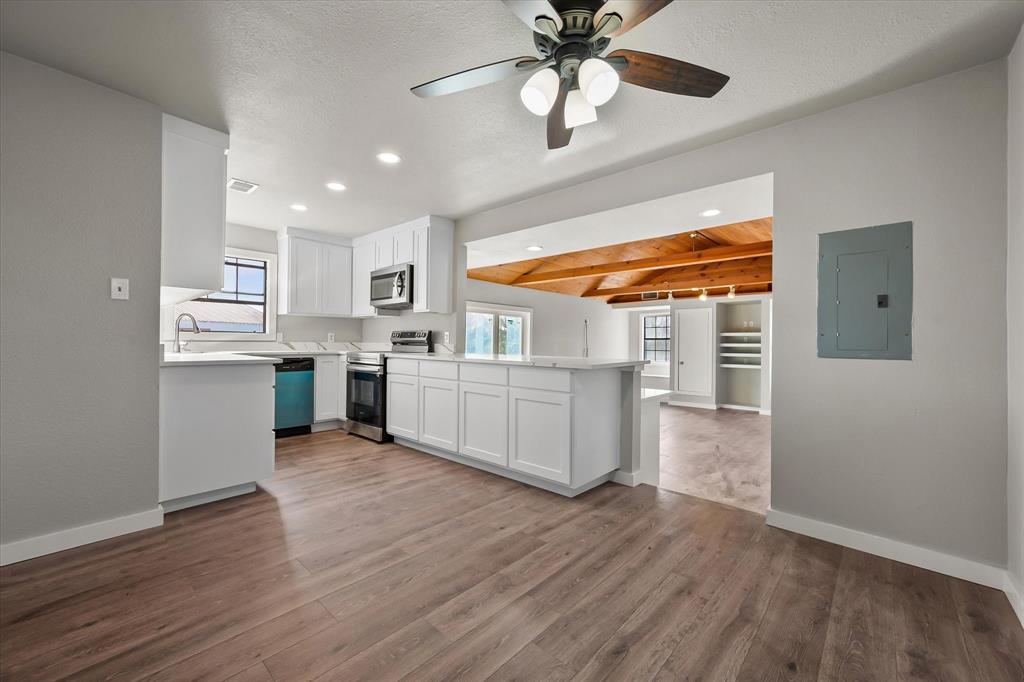 443 County Road 3799 Springtown, TX 76082 - Photo 33 of 33 Kitchen featuring open floor plan, light countertops, stainless steel appliances, white cabinetry, and beam ceiling