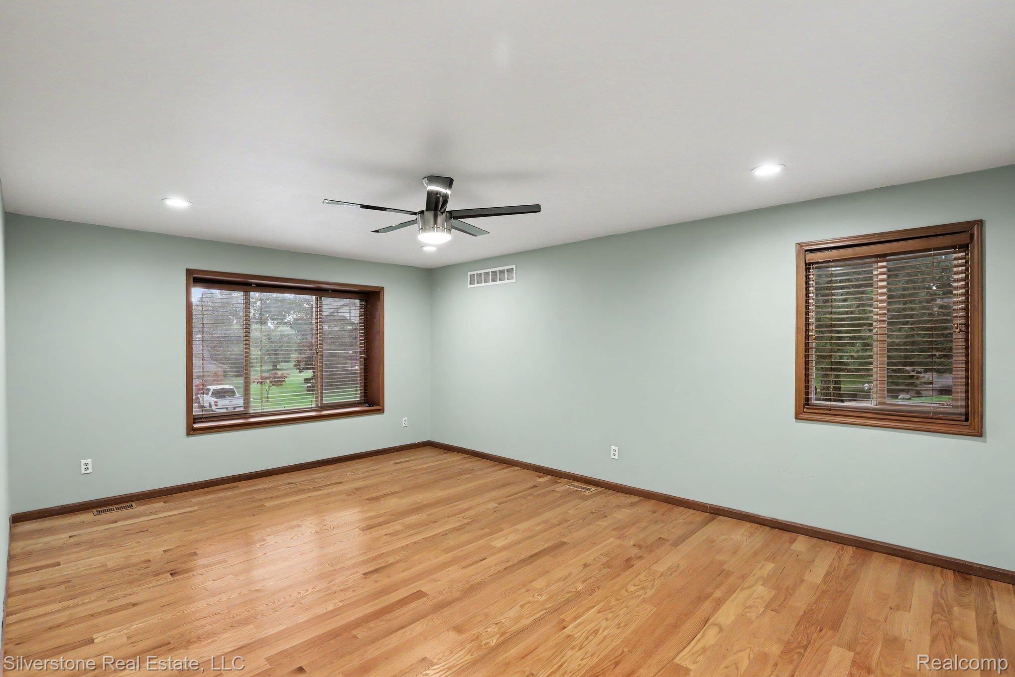 869 Timberline Drive Rochester, MI 48309 - Photo 11 of 29 Hardwood flooring, recessed lighting, ceiling fan with integrated light, and two windows with wood blinds