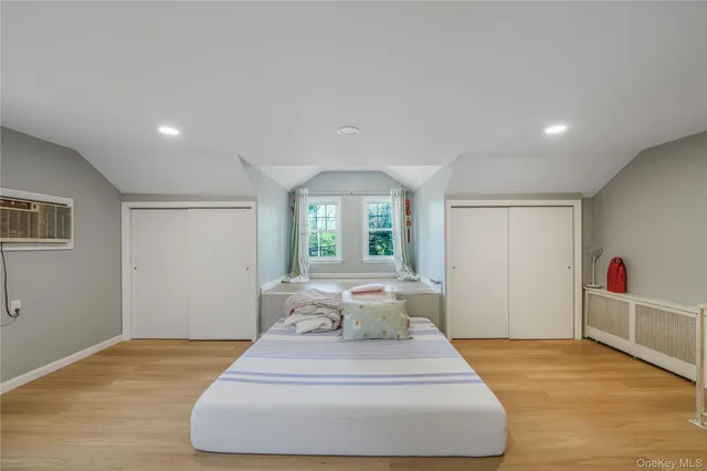 a spacious bedroom with a bed and wooden floor