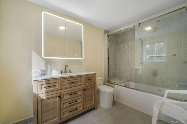 a bathroom with a granite countertop bathtub sink vanity and mirror