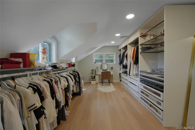 a view of walk in closet with clothes and shoes
