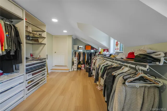 a view of walk in closet with clothes and shoes