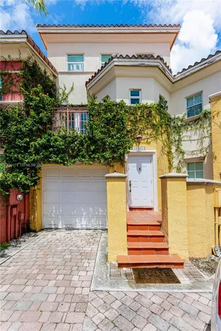 a front view of a house with a yard and potted plants