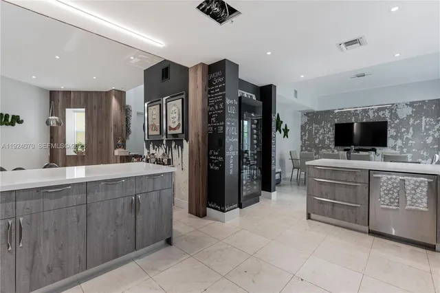 a kitchen with stainless steel appliances kitchen island granite countertop a refrigerator and a sink