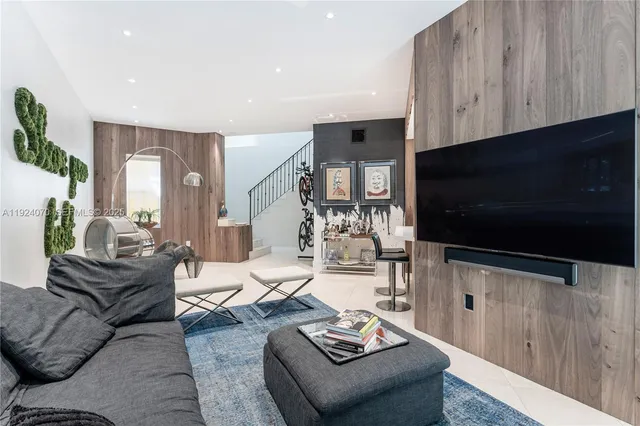 a living room with furniture a flat screen tv and kitchen view