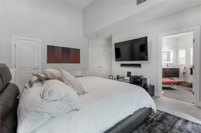 a bedroom with a bed and a flat tv screen on wall
