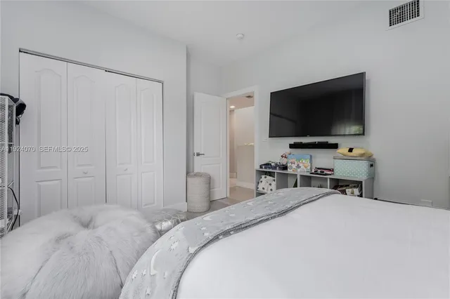 a bedroom with a bed and a flat screen tv