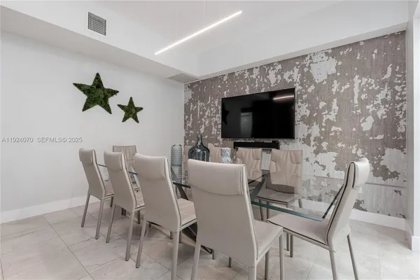 a dining room with furniture and a flat screen tv