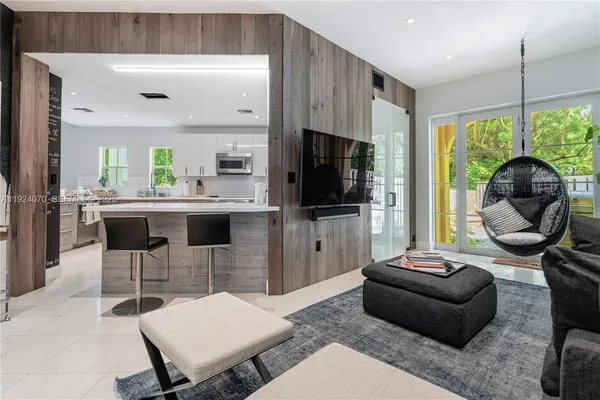 a living room with furniture a flat screen tv and a large window