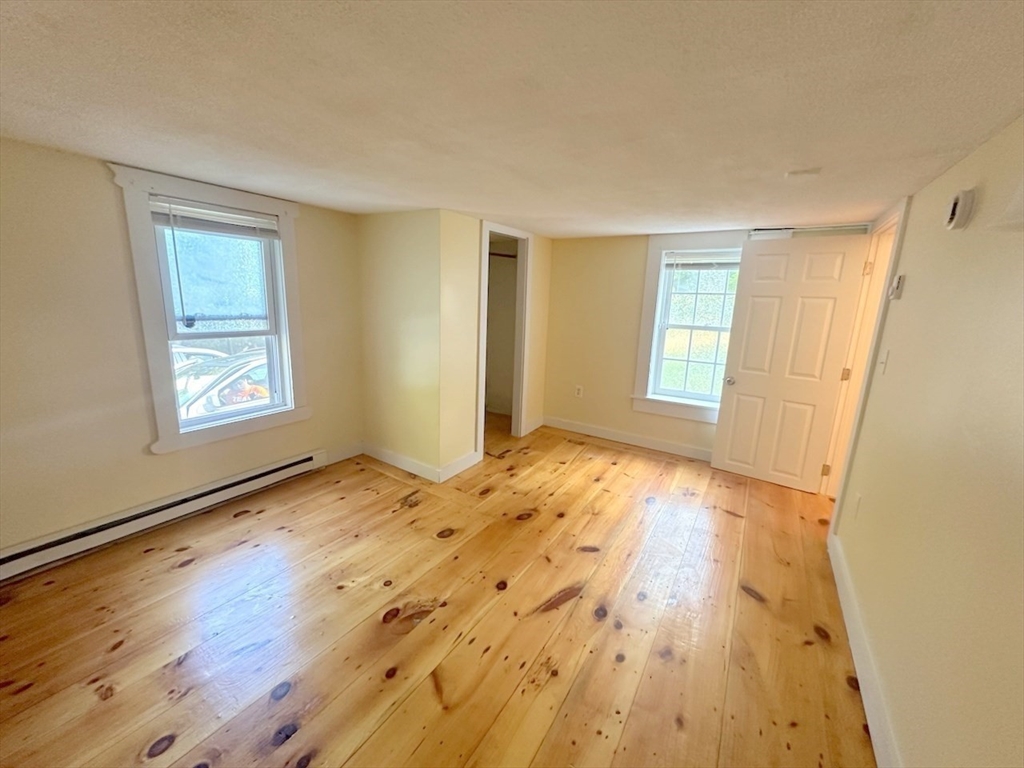 227 Bridge Street, Unit 3 Northampton, MA 01060 - Photo 9 of 19 a view of empty room with wooden floor and fan