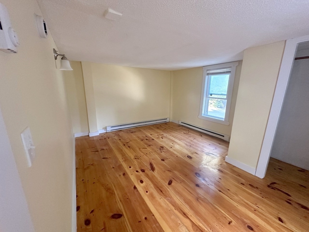227 Bridge Street, Unit 3 Northampton, MA 01060 - Photo 10 of 19 a view of empty room with wooden floor and fan