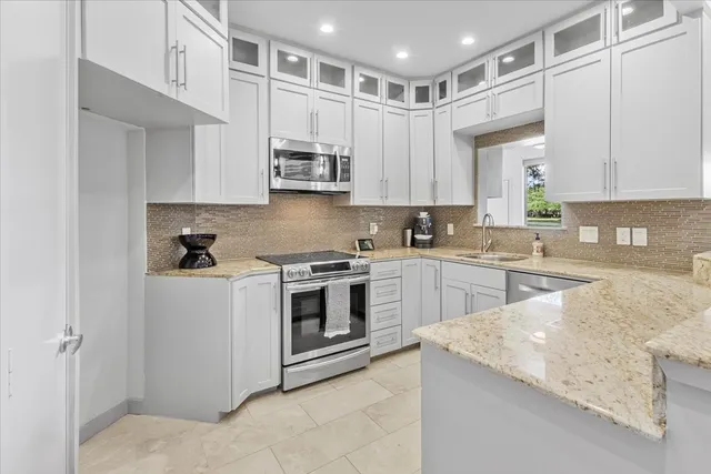 a kitchen with stainless steel appliances granite countertop a stove a sink and a refrigerator