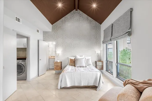 a bedroom with furniture and a large window