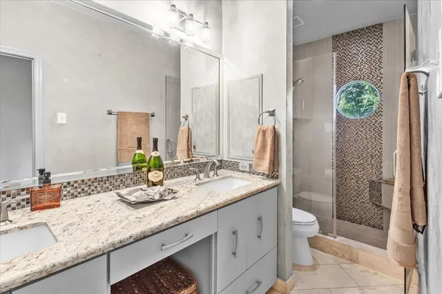 a bathroom with a granite countertop sink toilet and shower