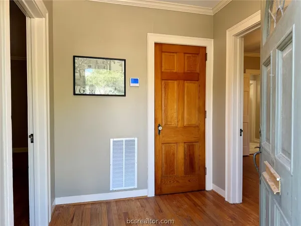 a view of a hallway with wooden floor and closet