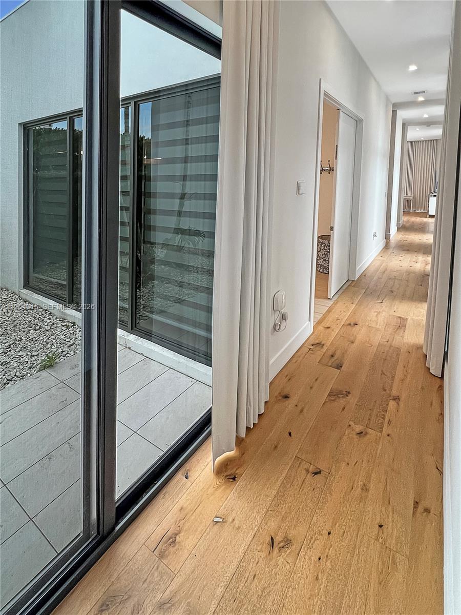 16640 Sunset Way Weston, FL 33326 - Photo 13 of 35 a view of a hallway with wooden floor and door