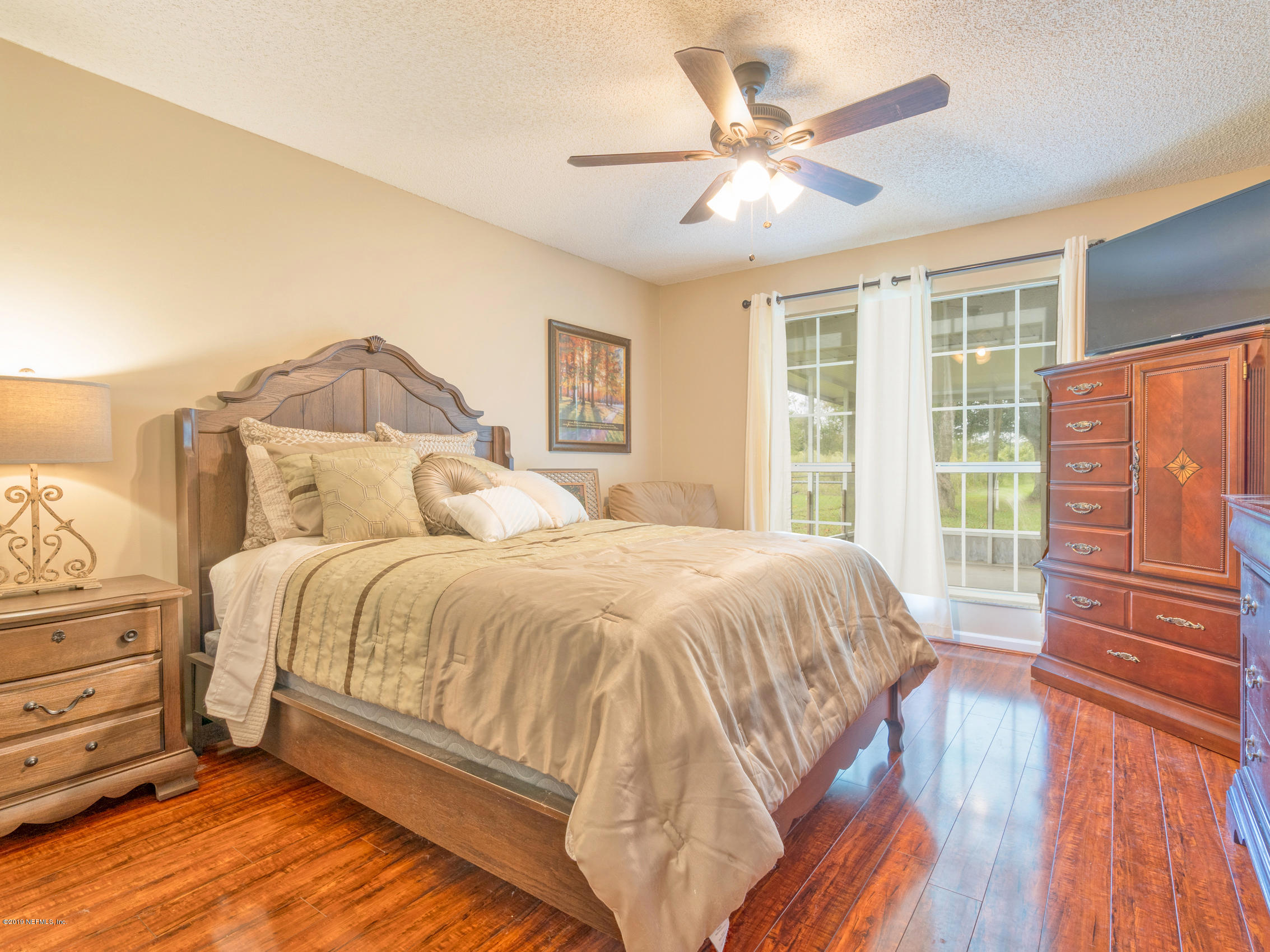 54201 Church Road Callahan, FL 32011 - Photo 21 of 37 a bedroom with a bed and wooden floor
