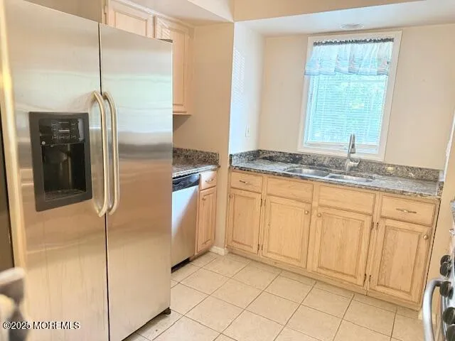a kitchen with stainless steel appliances granite countertop a refrigerator and a sink