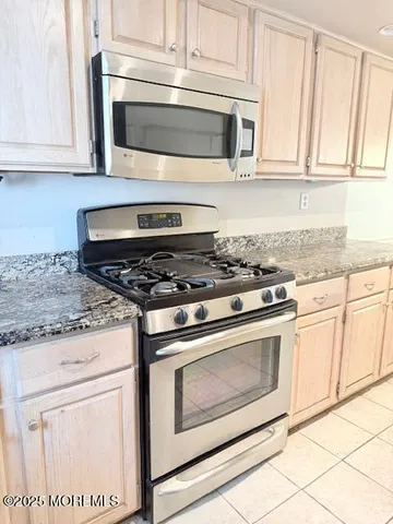 a kitchen with granite countertop white cabinets and appliances