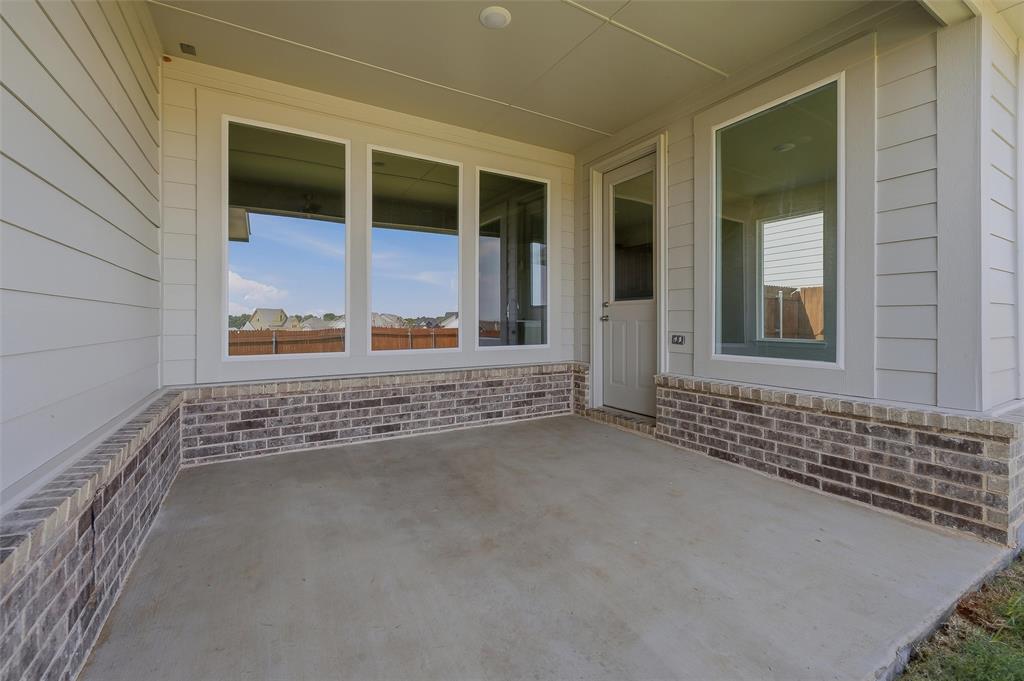 1201 Colca Drive Springtown, TX 76082 - Photo 28 of 32 Covered concrete patio with a brick wainscoting and horizontal siding