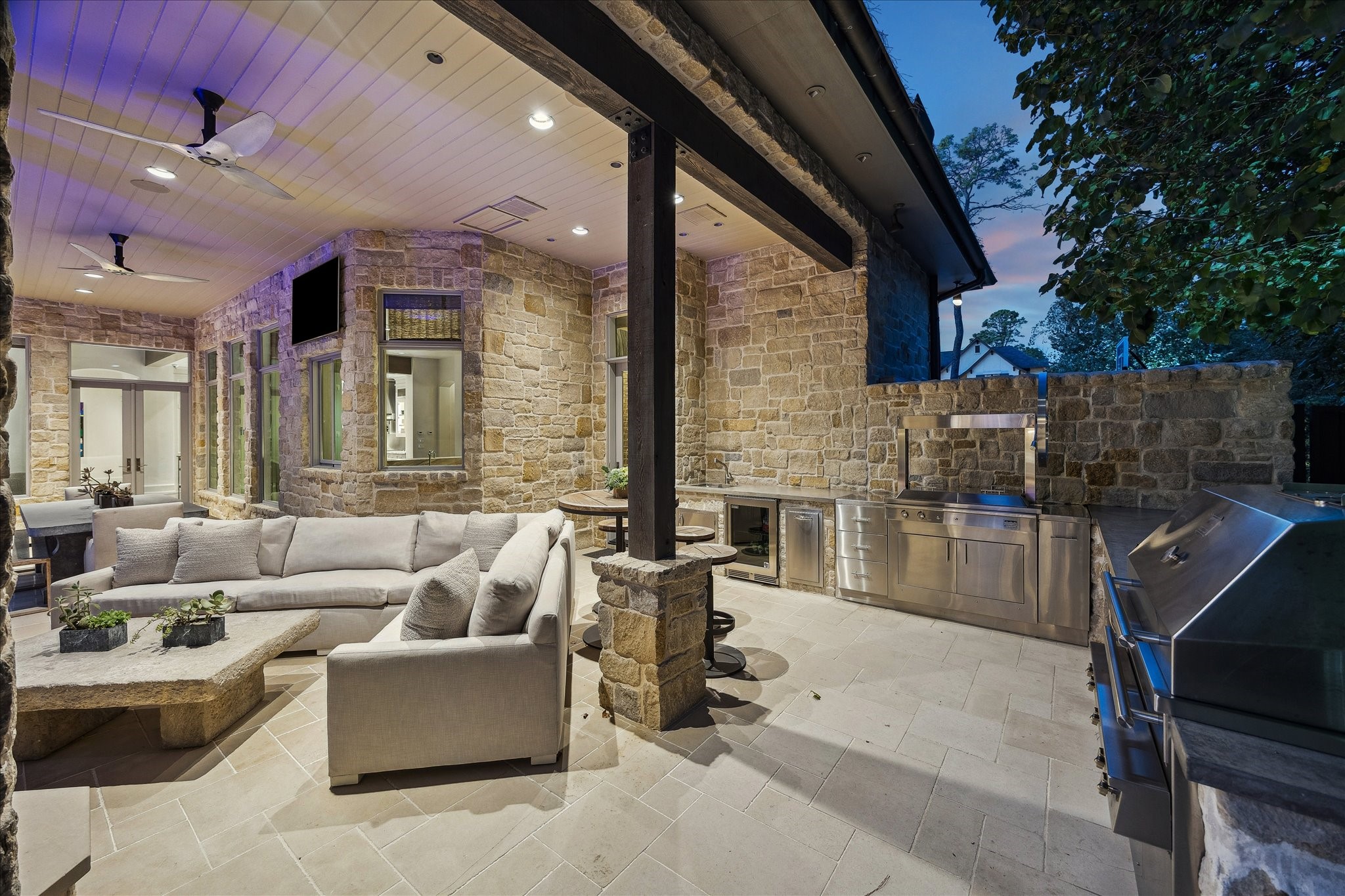 220 Merrie Way Lane Houston, TX 77024 - Photo 49 of 50 The backyard offers a resort-style outdoor living experience, highlighted by an expansive Kalamazoo grilling setup complete with a hybrid fire grill, Gaucho grill with motorized rotisserie, Perlick beverage refrigerator, Blanco stainless steel sink, air-switch disposal, and stainless-steel trash and spice pullouts.