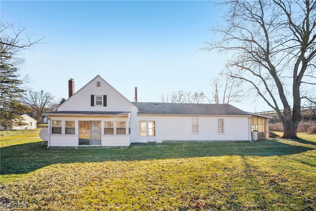 754 Fettro Road Akron, OH 44312 - Photo 28 of 31 Rear view of property with a lawn, a sunroom, and a chimney