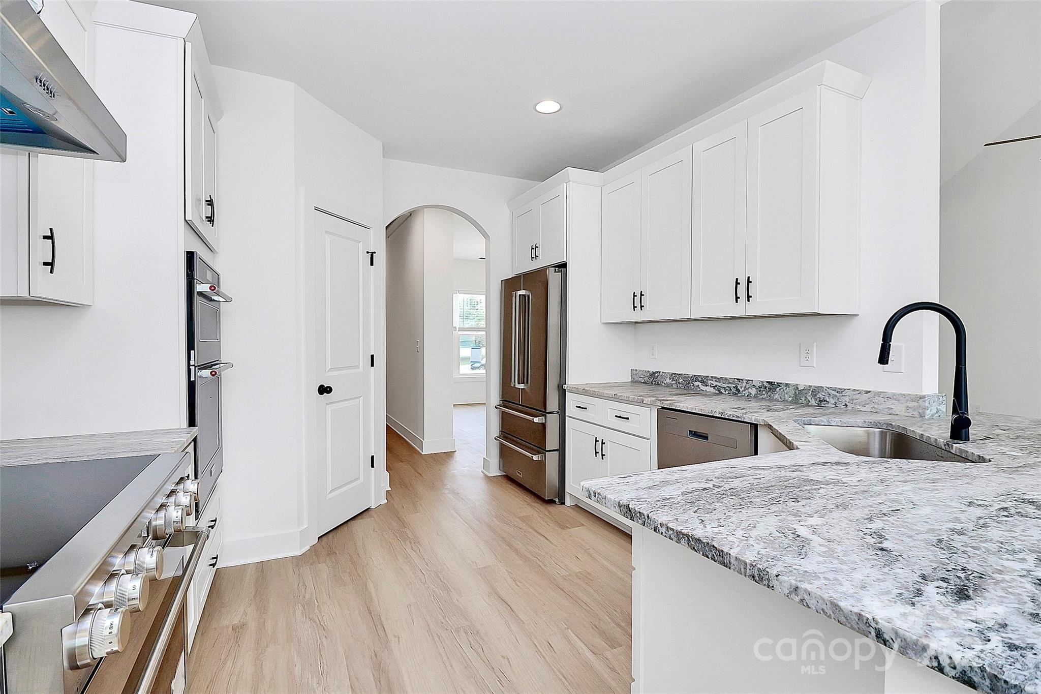 115 Starmount Drive Kings Mountain, NC 28086 - Photo 11 of 39 a kitchen with stainless steel appliances granite countertop a stove top oven a sink and dishwasher with wooden floor