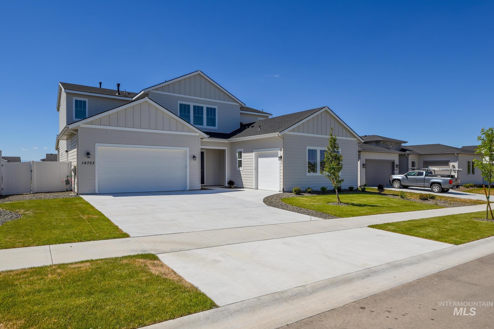 14703 Serenity Pt Street Caldwell, ID 83607 - Photo 2 of 45 Two-story residence featuring light gray siding with vertical accent panels, a dark asphalt shingle roof, and multiple white-framed windows