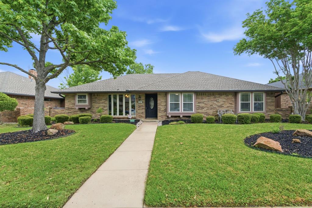 2307 Castle Rock Road Carrollton, TX 75007 - Photo 1 of 34 The property features a brick exterior, a well-maintained front lawn, a paved walkway leading to the entrance, and mature trees providing shade