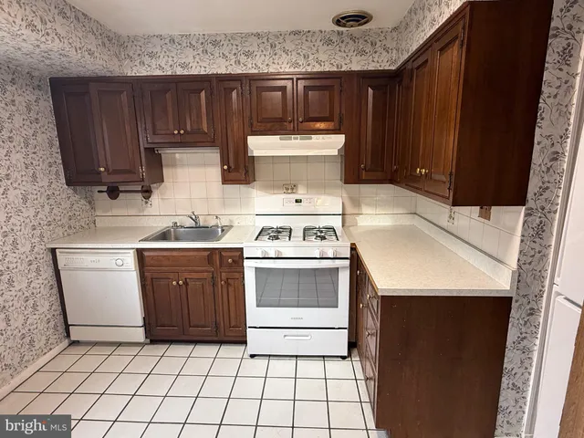 a kitchen with a sink a stove and cabinets