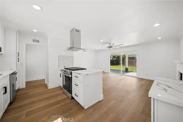 a kitchen with granite countertop a sink stove and cabinets