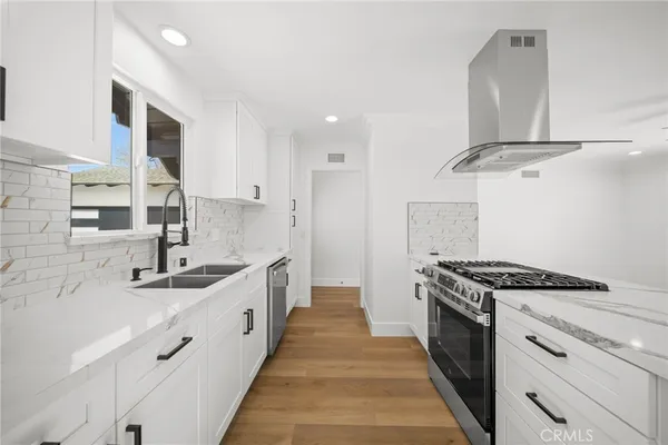 a kitchen with stainless steel appliances a sink stove and cabinets
