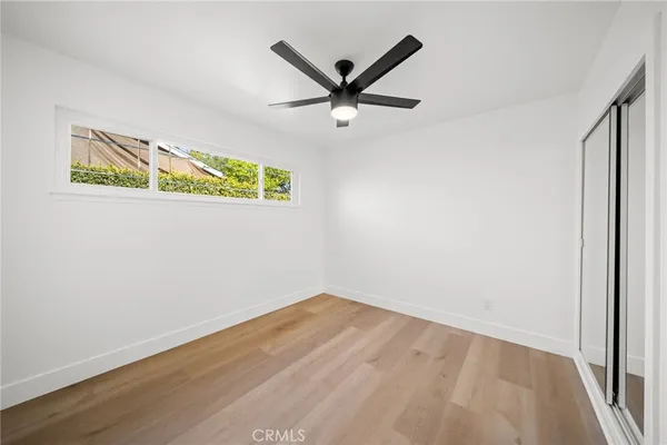 a view of empty room with wooden floor