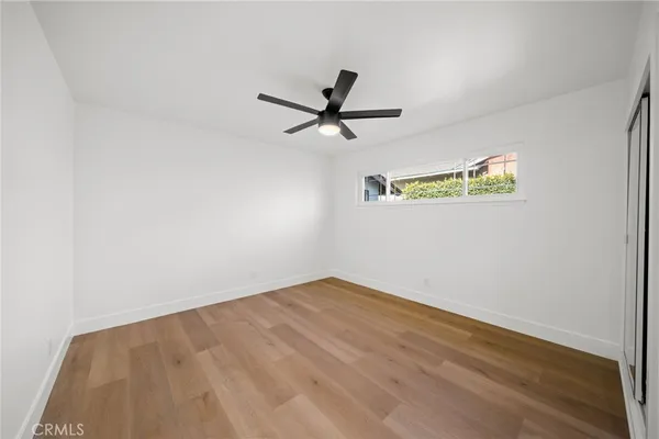 a view of a big room with wooden floor and windows
