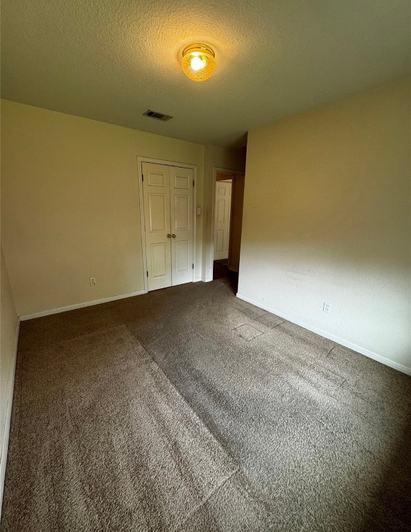 8613 Talyne Chaise Circle Austin, TX 78729 - Photo 15 of 22 Unfurnished bedroom with a textured ceiling, carpet floors, and a closet