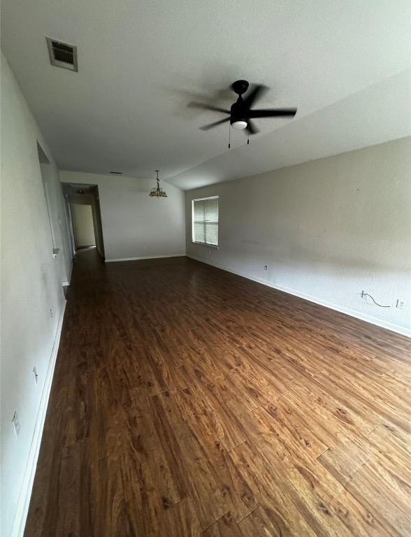 8613 Talyne Chaise Circle Austin, TX 78729 - Photo 3 of 22 Spare room featuring dark wood-style floors, a chandelier, and a ceiling fan