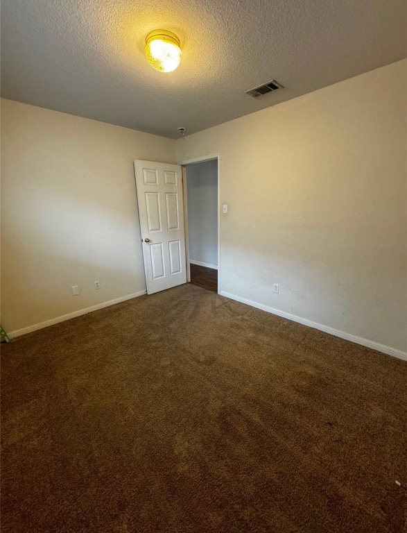 8613 Talyne Chaise Circle Austin, TX 78729 - Photo 7 of 22 Spare room with a textured ceiling and dark colored carpet