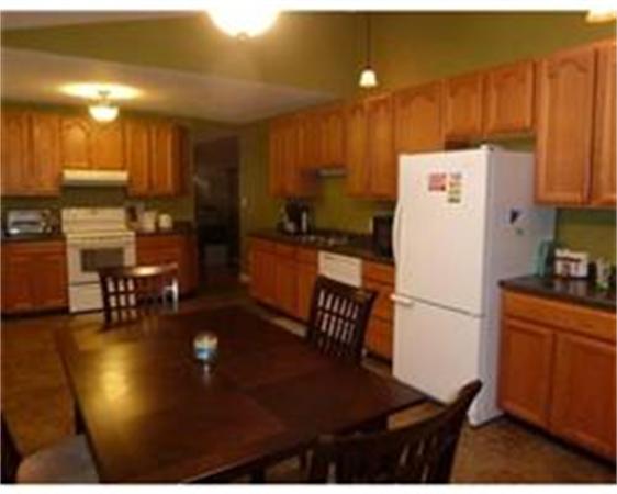 119 North Street Three Rivers, MA 01080 - Photo 4 of 6 a kitchen with a refrigerator a stove and a dining table with wooden floor