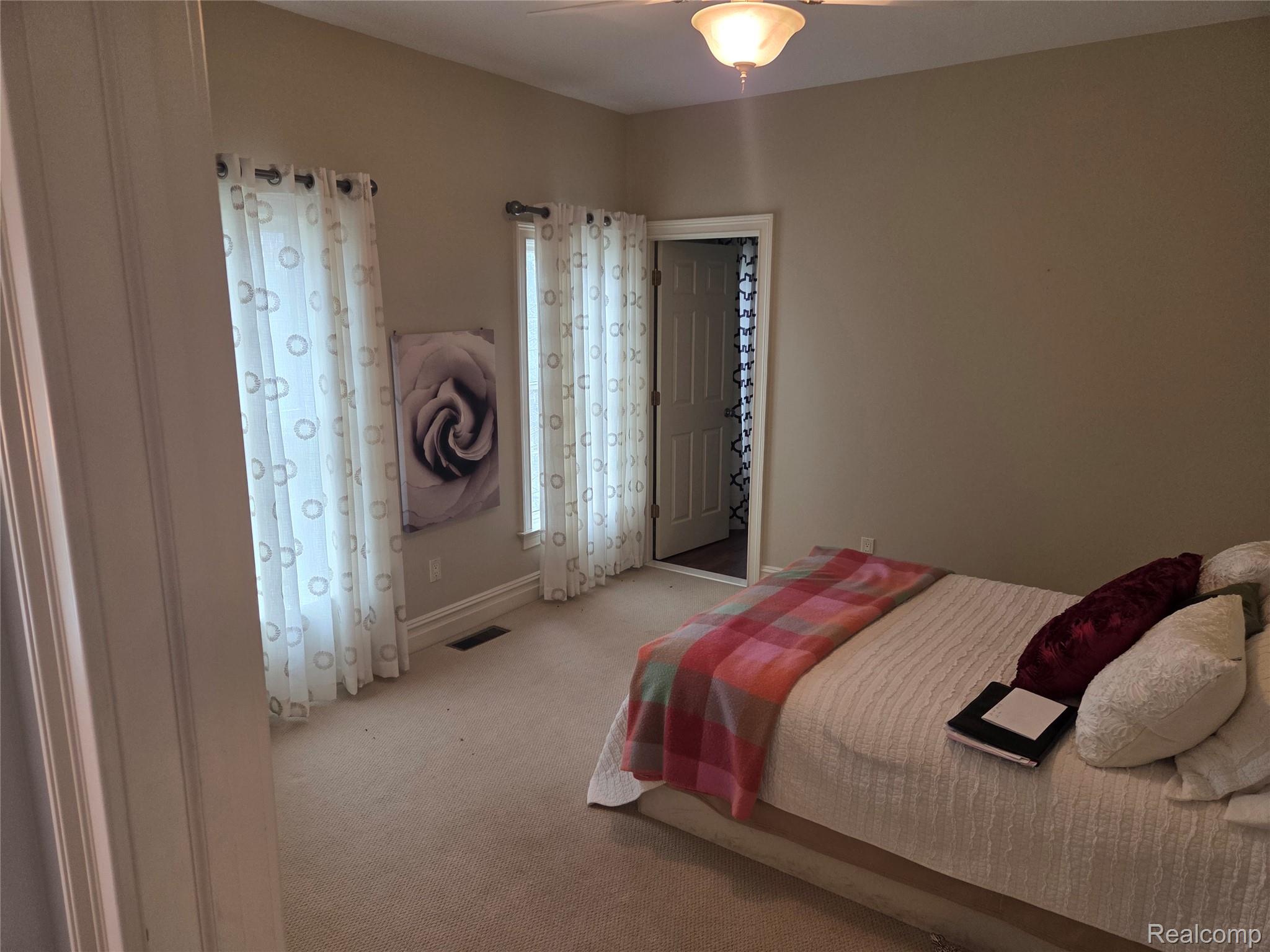 900 South Maxfield Road Brighton, MI 48114 - Photo 8 of 30 Bedroom featuring light carpet and a ceiling fan