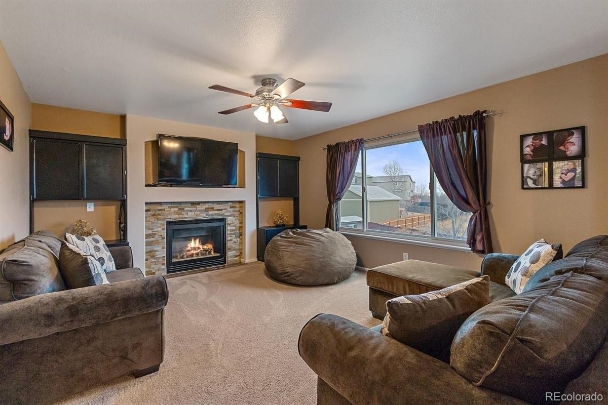 7751 Old Spec Road Peyton, CO 80831 - Photo 3 of 17 a living room with furniture a fireplace and a flat screen tv