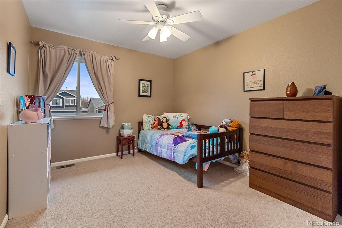7751 Old Spec Road Peyton, CO 80831 - Photo 10 of 17 a bedroom with a bed and a chandelier