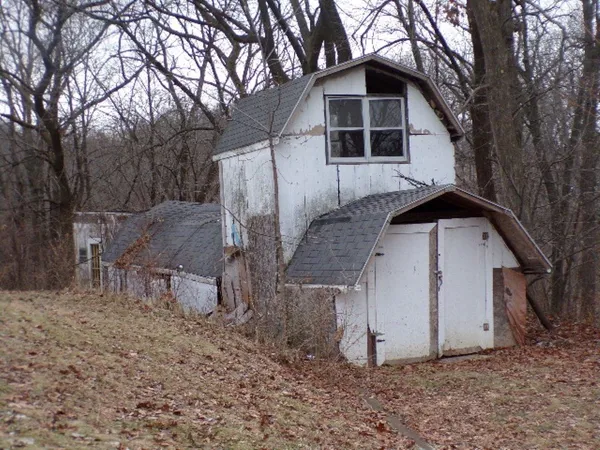 a front view of house with yard and trees in the background